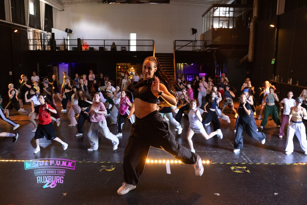 Trainerin f&uuml;hrt einen gro&szlig;en Streetdance-Workshop im Saal an